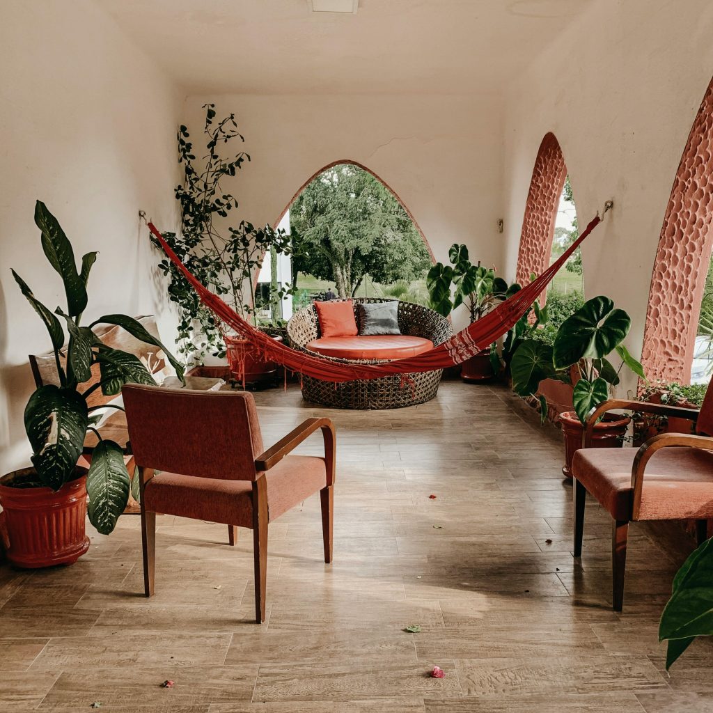 Boho dizajnirana terasa sa mrežom za ležanje, zelenilom i rustičnim nameštajem